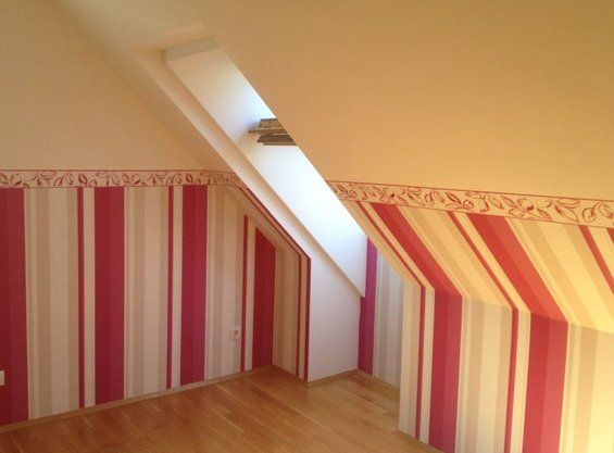 Dachzimmer mit dekorativer Streifen-Wandgestaltung in Korallrot und Creme